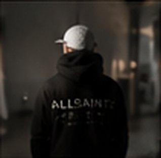 Creator in a hoodie and cap from behind